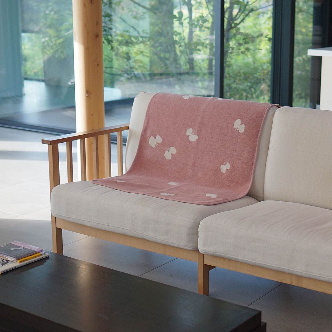 ソファに掛けたシュニールコットン ピンクのミニブランケット