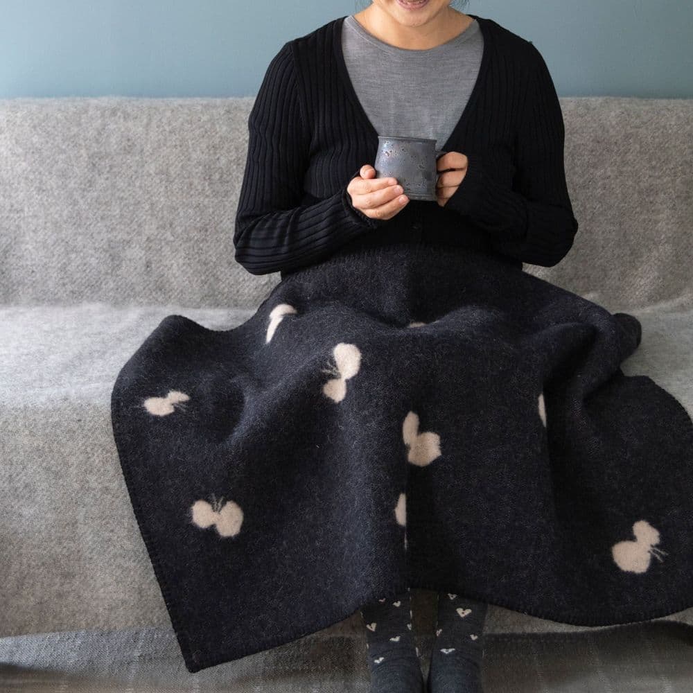 ブラックのウールミニブランケットをひざ掛けにして温まる様子