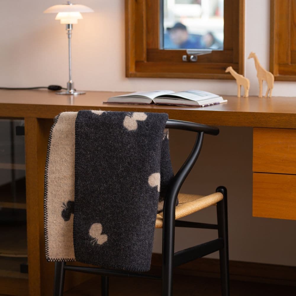 デスクチェアに掛けたブラックのウールブランケット