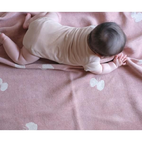 ピンクのCHOUCHOの上で腹ばいになる赤ちゃん