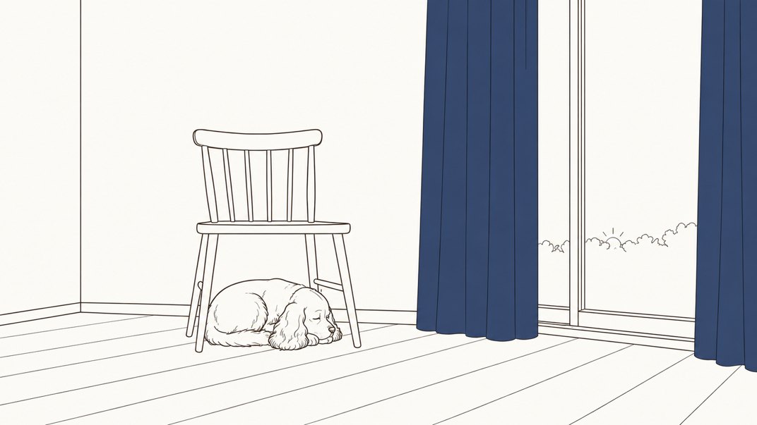 カーテンの開いた部屋で、椅子のそばに伏せているエル