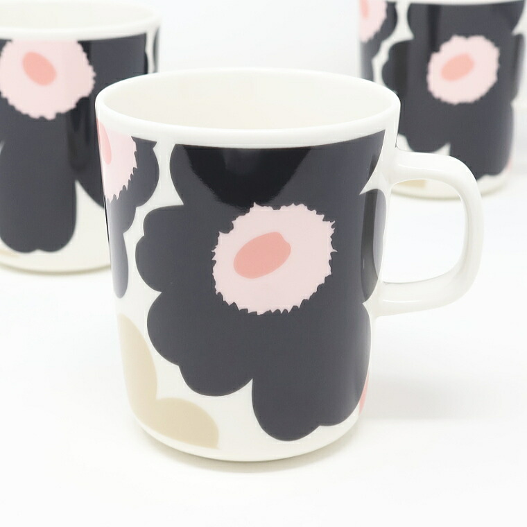 白地に濃いチャコールの花が入ったマグカップを斜めから見たところ。うしろに同じマグが2つ
