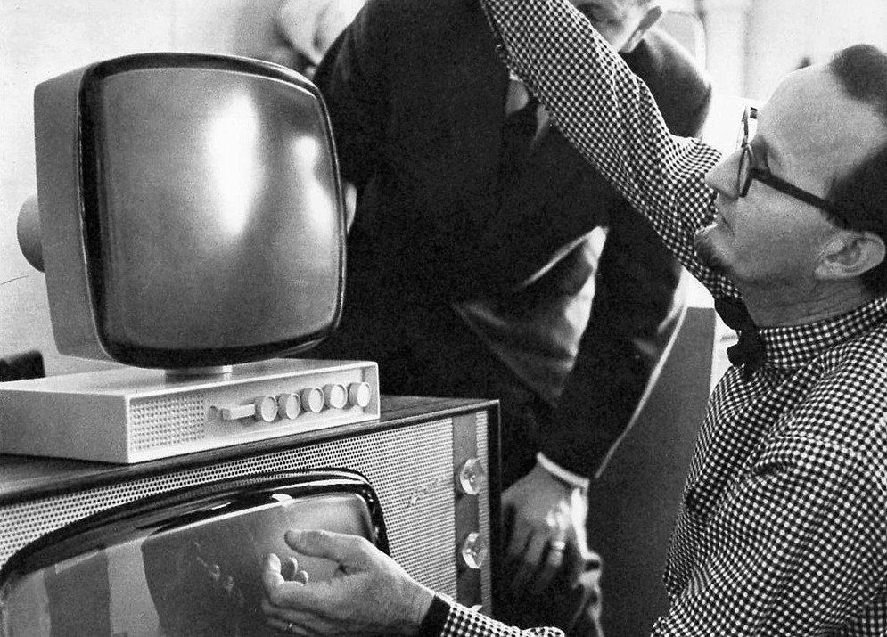 テレビの試作品に手をかけるスティグ・リンドベリ。格子柄のシャツに蝶ネクタイ。1959年の白黒写真